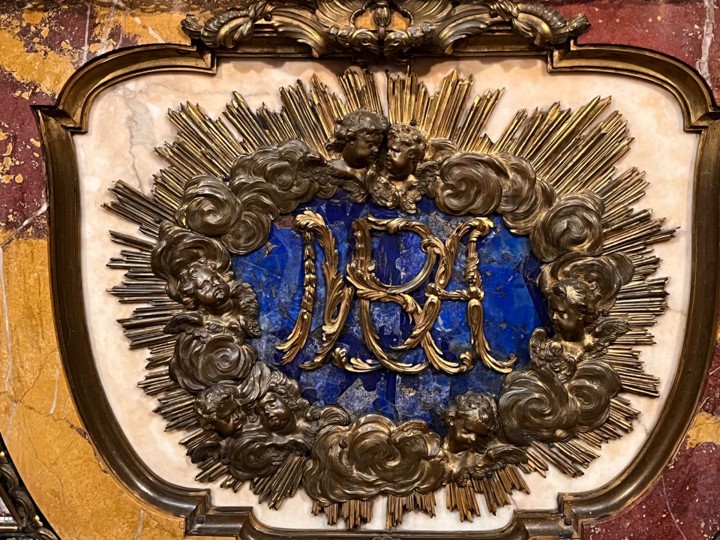 fig 4 Bajo el cuadro de la Visitación resalta el altar mayor, cuyo frontal se realizó en Roma a base de un mosaico floral de teselas de piedras duras, en cuyo centro y sobre lapislázuli, se leen en bronce dorado las iniciales de los reyes Fernando y Bárbara